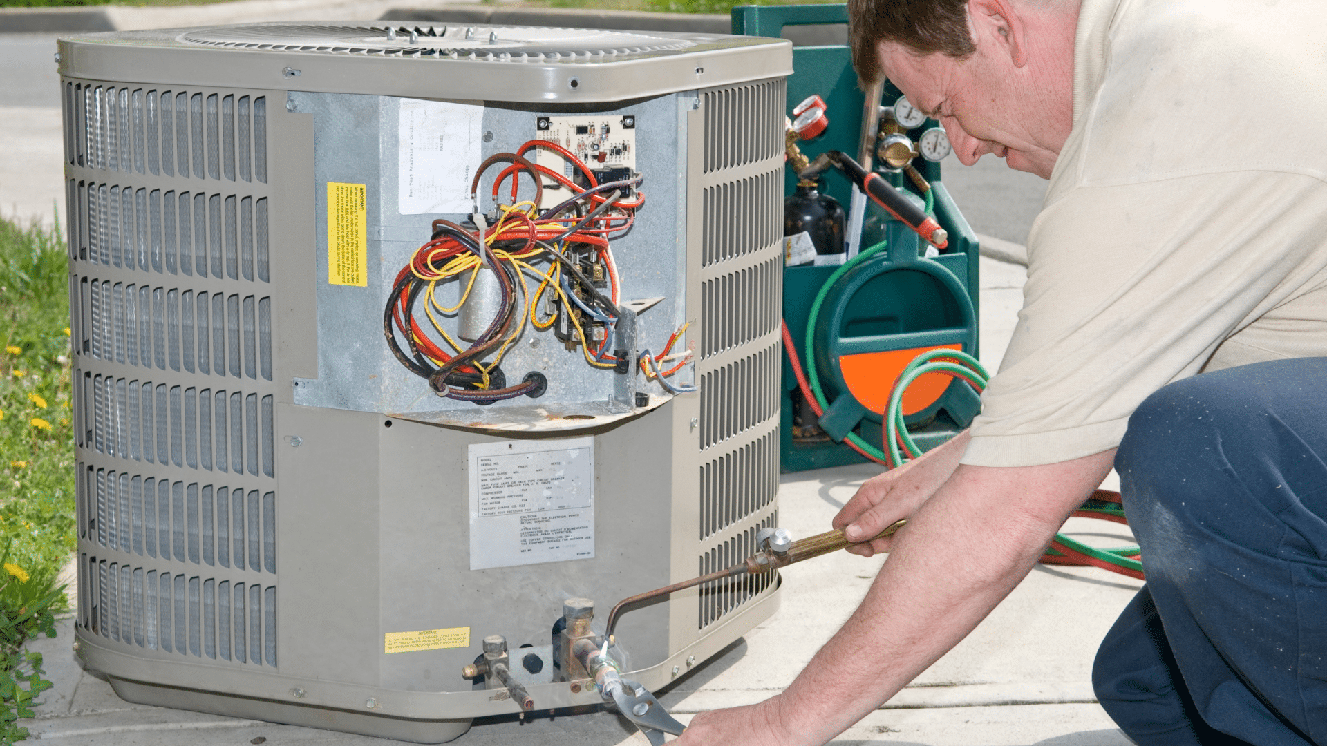Image of a man repairing an AC compressor.